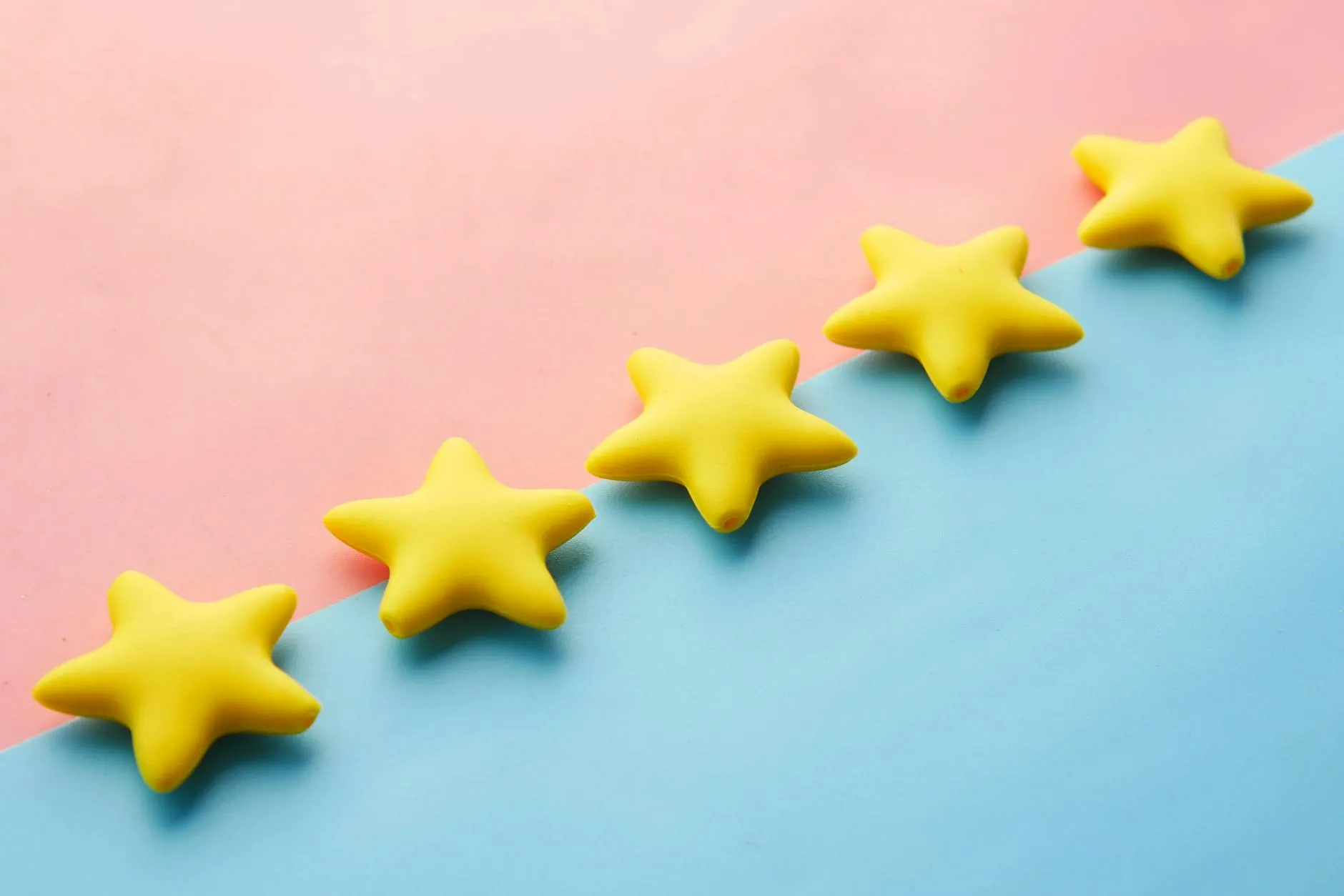 Five yellow stars on pastel background