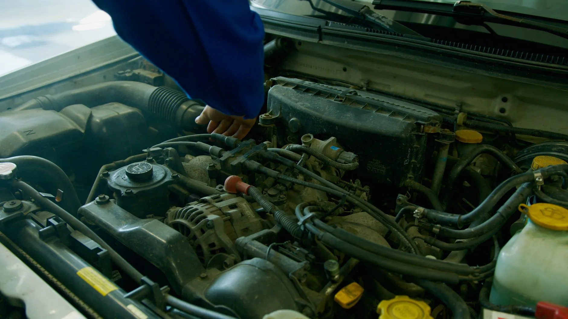 Mechanic inspecting a used car engine bay before purchase