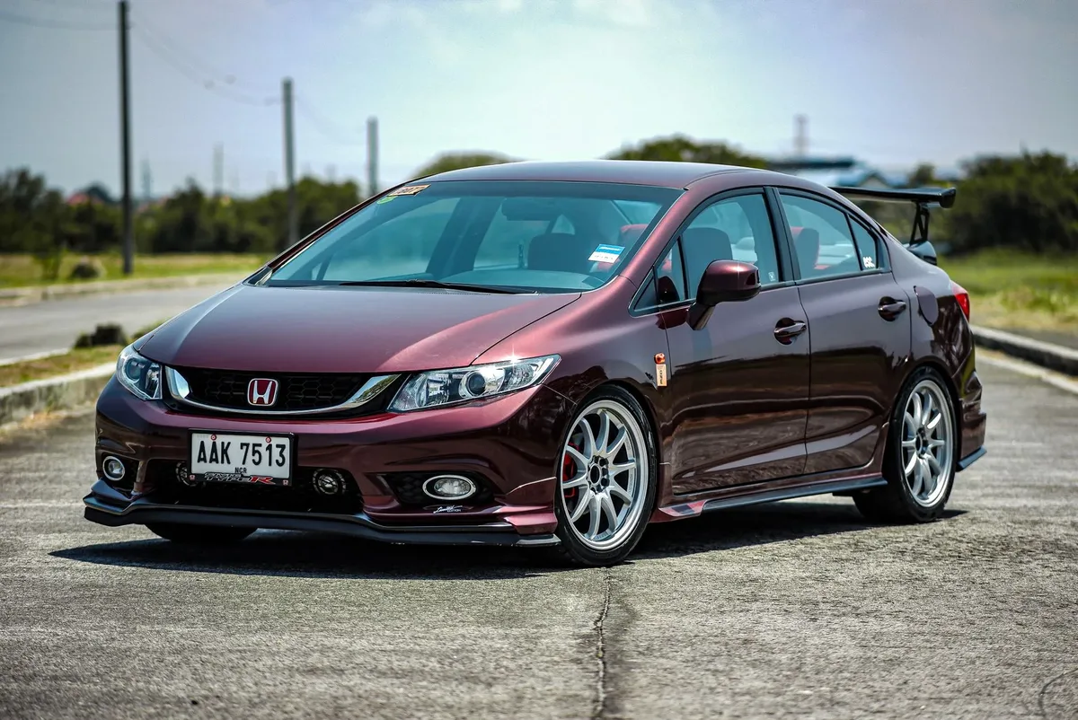 Maroon ninth-generation Honda Civic sedan parked on a sunny road