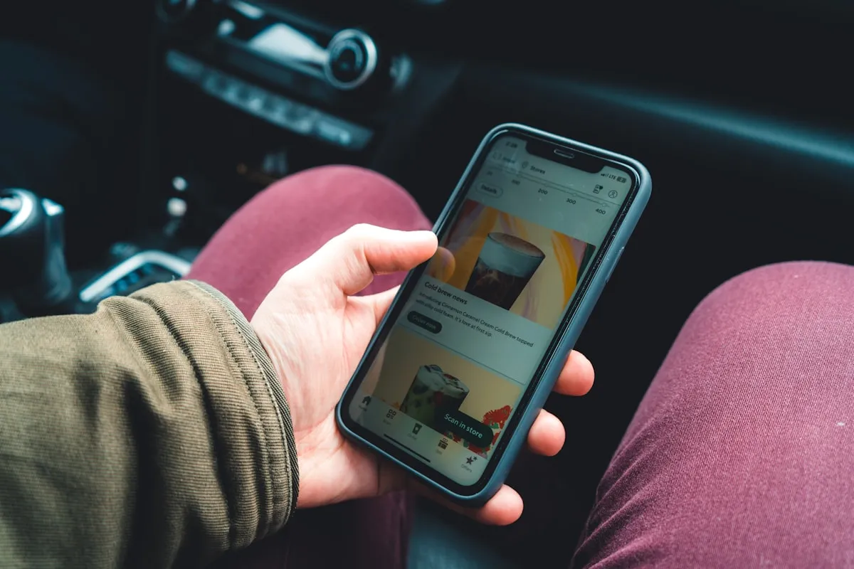 Person browsing listings on a smartphone inside a parked car