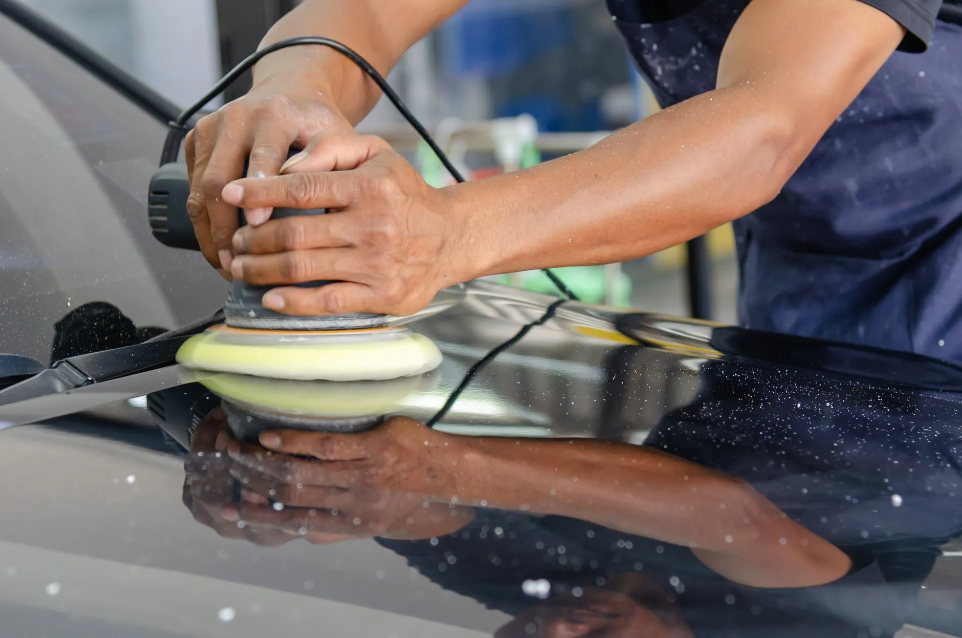 Machine polishing the hood of a used car before resale