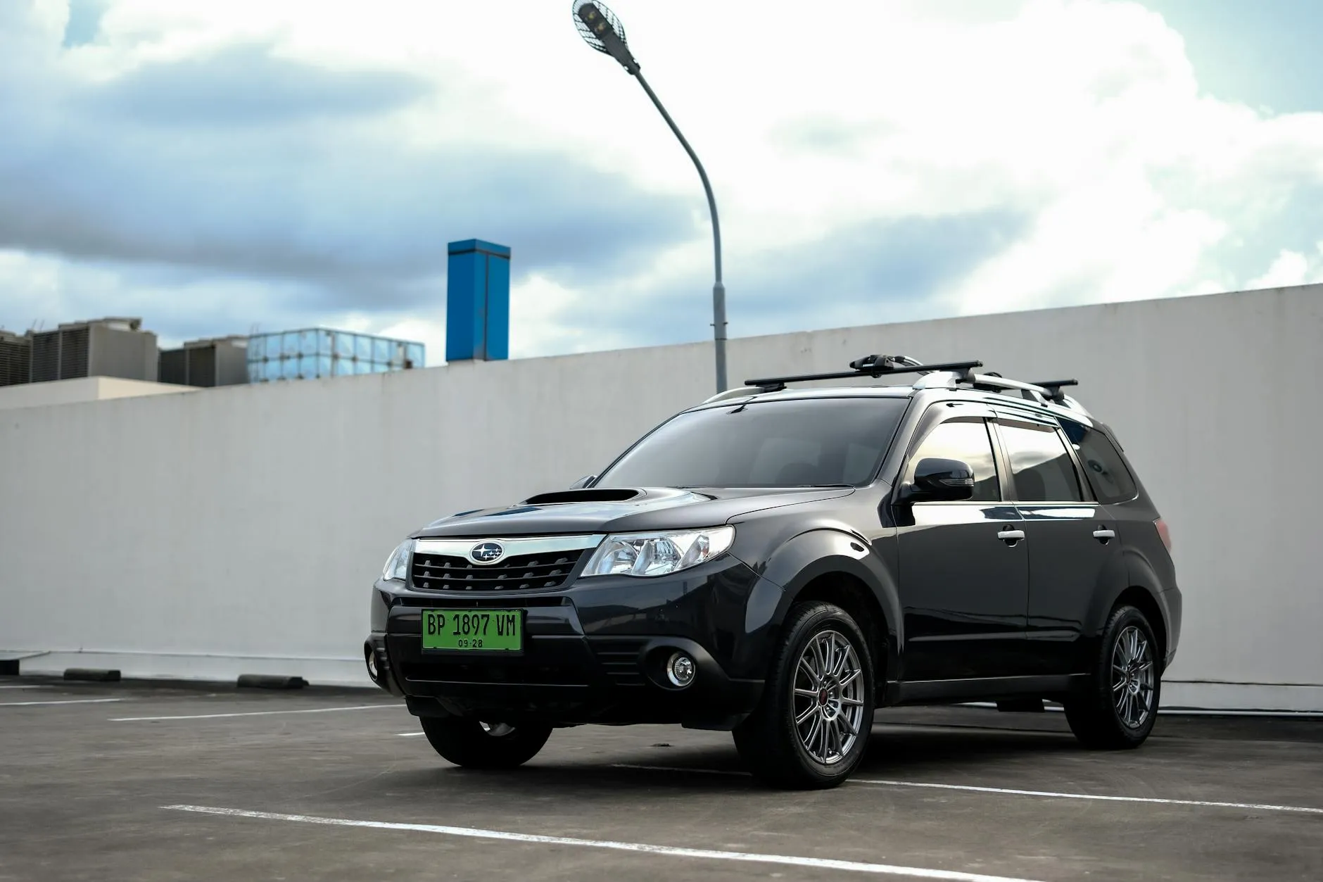 Black Subaru Forester in urban parking lot