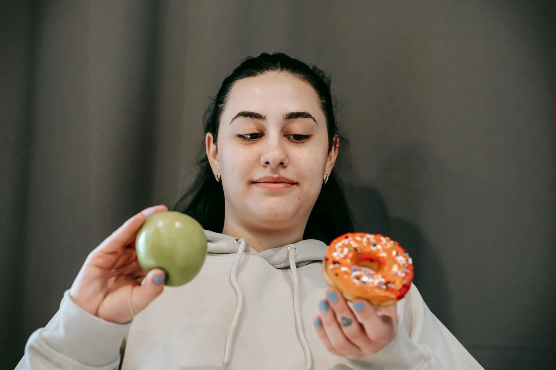 Woman choosing between apple and donut