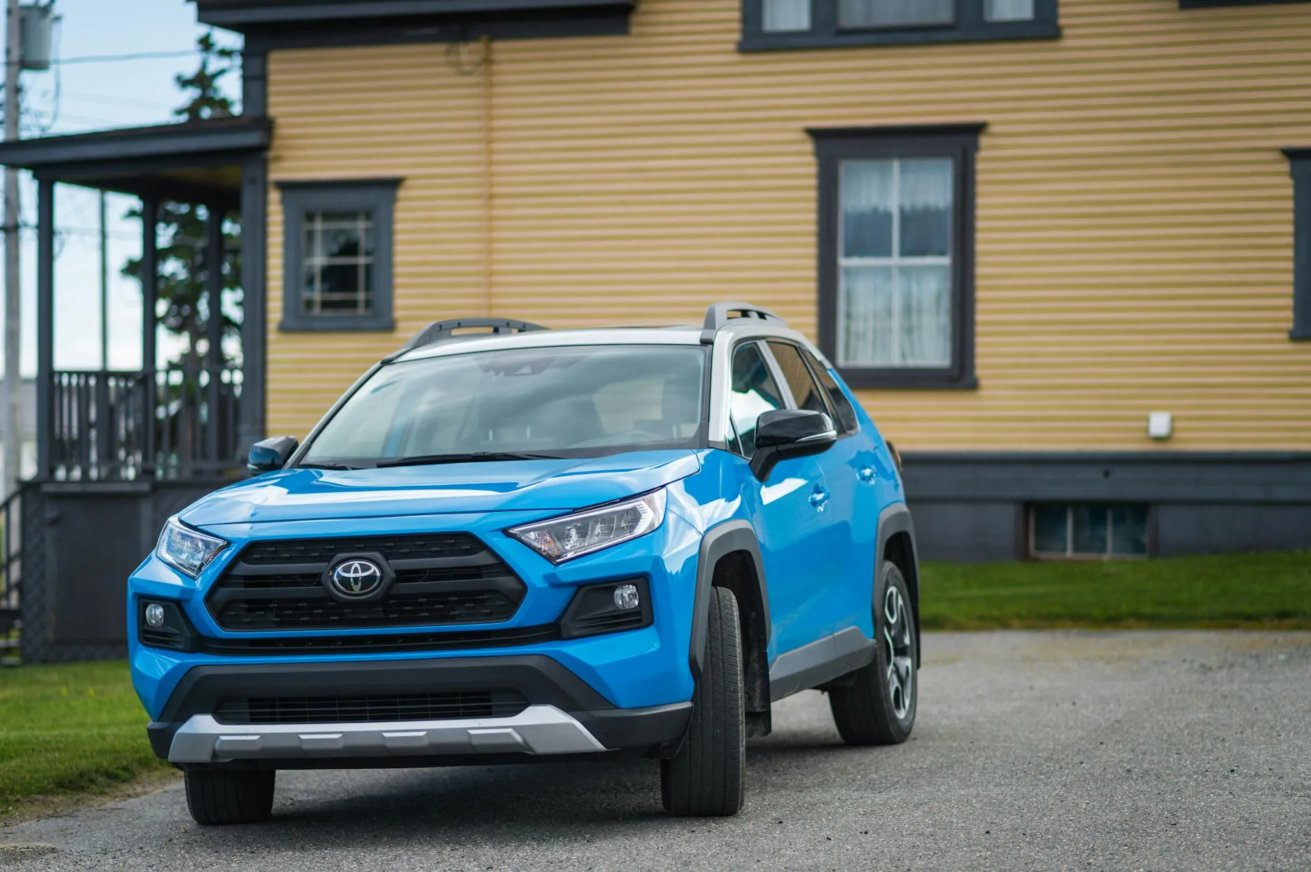 Blue Toyota RAV4 parked outside a house