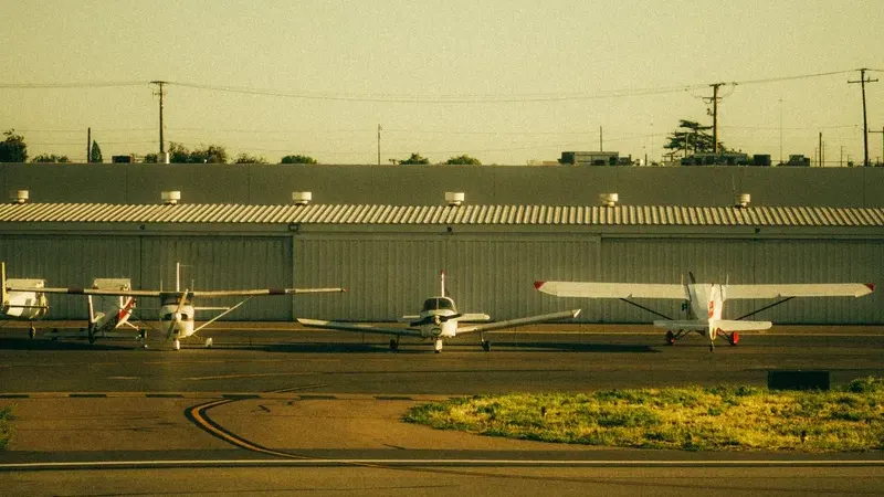 Single-engine piston aircraft tied down on a grass airfield